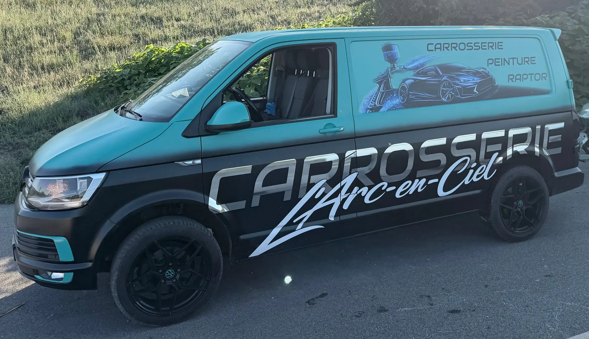 Le fourgon de la Carrosserie L’Arc en Ciel, peint en vert Petronas et noir, lettrage du garage sur le flanc